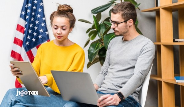 J-1 Specialist visa holder reviewing W-2 tax form and paystub for U.S. income tax filing