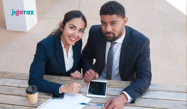 J-1 employer end-of-year tax responsibilities checklist showing W-2 forms, withholding records, and FICA exemption documents on a desk